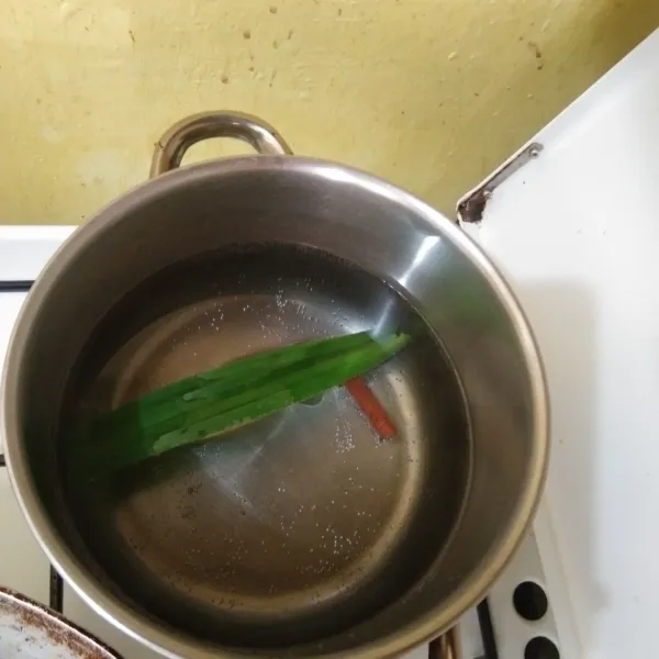 Rebus air yang baru beserta daun pandan dan kayu manis hingga mendidih.