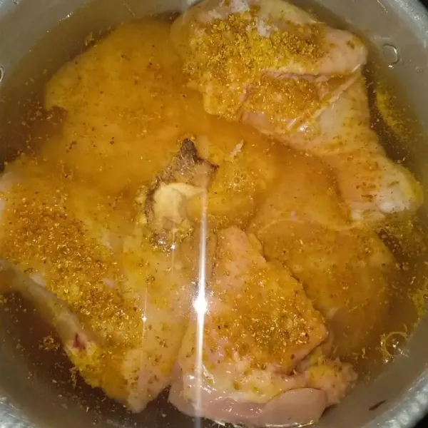 Siapkan panci, beri air, kunyit, garam, jahe, air jeruk nipis, aduk rata. Masukkan ayamnya dan ungkep atau rebus hingga matang.