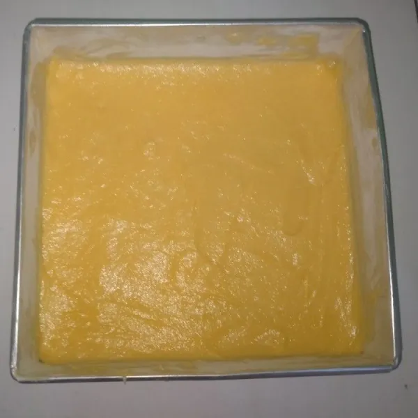 Setelah adonan tercampur merata, masukkan adonan kedalam loyang yang sudah diolesi tepung & margarin. Ratakan adonan menggunakan spatula & hentak-hentakan adonan agar udara di dalam bisa keluar