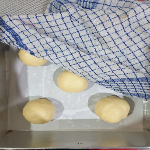 Bagi adonan roti menjadi 8 pcs @65gr, lalu dibentuk bulat dan ditaruh ke cetakan kue yang sudah diberi kertas roti dan minyak lalu didiamkan dalam keadaan tertutup serbet selama 1 jam.