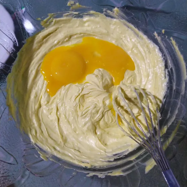 Masukkan dua butir kuning telur, aduk hingga tercampur rata.