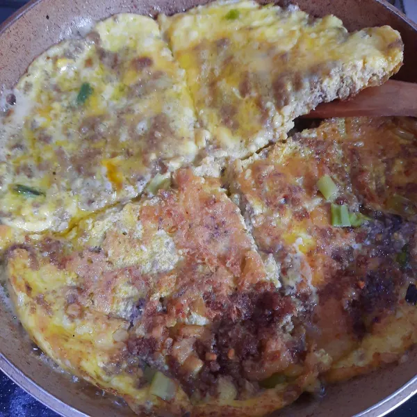 Tips jika telur dadar sulit dibalik: setelah bagian bawah cukup kokoh dan berkulit, bagi telur menjadi 4 bagian dengan sutil kayu. Balik telur satu per satu. Masak hingga semua sisinya matang.