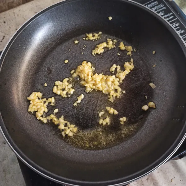 Tumis bawang putih hingga harum.