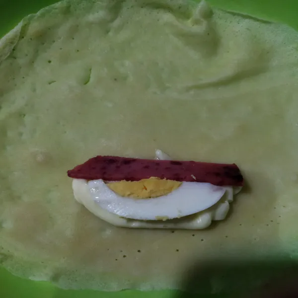 Penyelesaian : ambil 1 lembar kulit risol lalu beri isiaan mayones secukupnya, potongan telur rebus dan daging burger, kemudian dilipat.