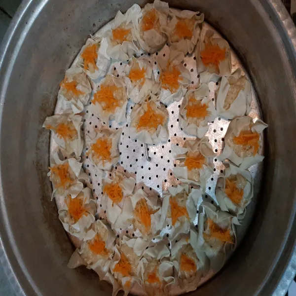 Selanjutnya beri toping wortel parut di atasnya untuk menambah warna. Lalu kukus hingga matang. Dimsum siap disajikan.