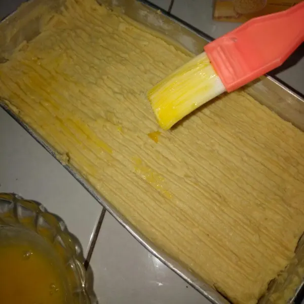 Siapkan loyang, alasi dengan kertas roti. Tuang adonan leker ke dalam cetakan, lalu gerat bagian atas dengan garpu
