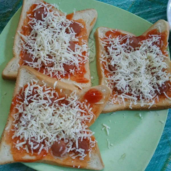 Tambahkan sosis diatasnya dan taburi dengan keju parut.