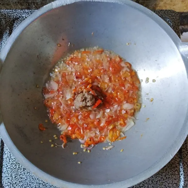 Ketika sudah agak layu, masukkan bawang putih yang sudah dihaluskan bersama terasi dan garam, aduk rata.