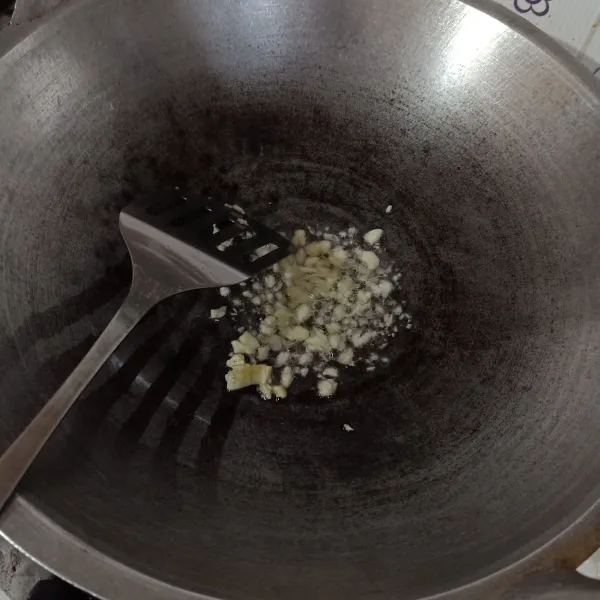 Tumis bawang putih dengan sedikit minyak goreng sampai harum.