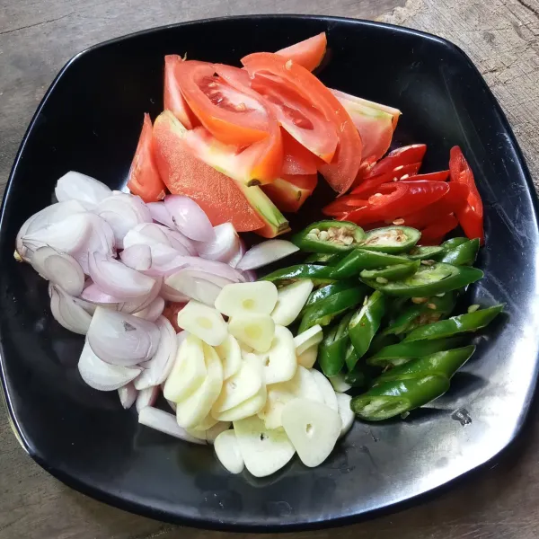 Iris tipis bawang merah dan bawang putih, potong-potong cabai dan tomat.