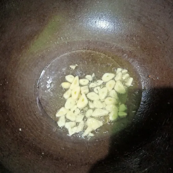 Siapkan wajan lain lalu beri minyak goreng sedikit lalu masukkan irisan bawang putih. Oseng sampai tercium harum.