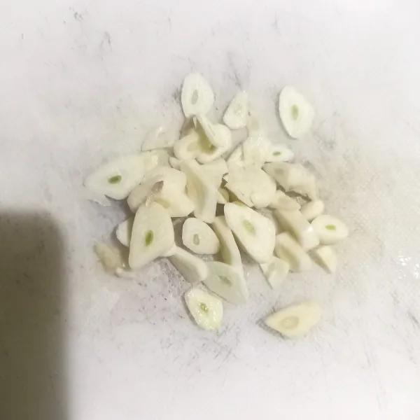 Lalu kupas dan iris tipis bawang putih.