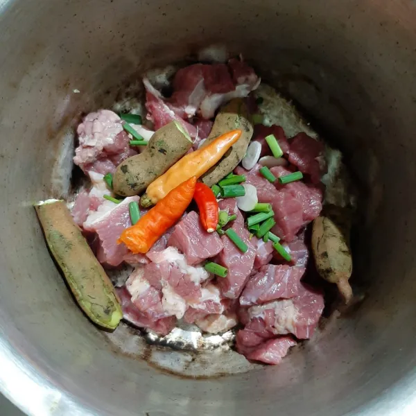 Tambahkan irisan bawang, cabe rawit, dan asam muda.