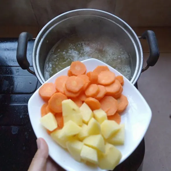 Masukkan wortel dan kentang ke dalam rebusan daging dan kacang hijau yang telah lunak, masak sampai sayur setengah lunak