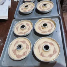 Olesi loyang dengan carlo. Tuang adonan kuning 3/4 tinggi loyang. Isi dengan adonan coklat, tarik melingkar adonan coklat dengan tusuk sate untuk membuat motif.