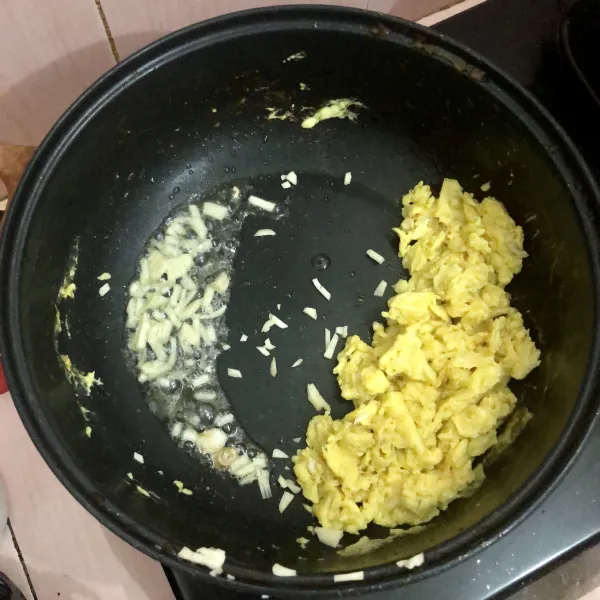 Tumis bawang putih hingga harum, kemudian aduk rata dengan telur