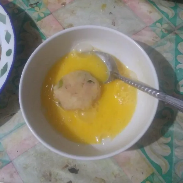 Kocok telur hingga rata. Lalu masukkan satu bulatan perkedel. Balur rata.