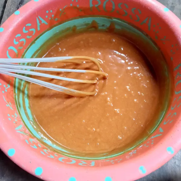 Tuang air karamel ke dalam campuran tepung, aduk perlahan hingga tercampur rata.