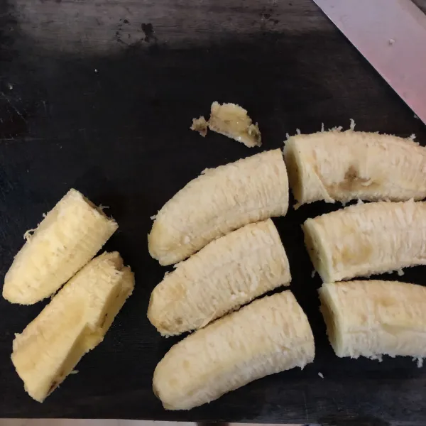 Kupas pisang lalu potong-potong sesuai selera.