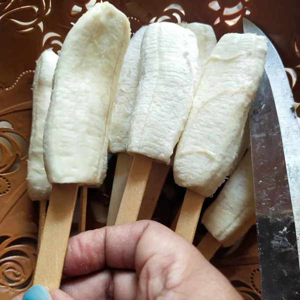 Kupas kulit pisangnya kemudian di tusuk dengan tusuk es krim