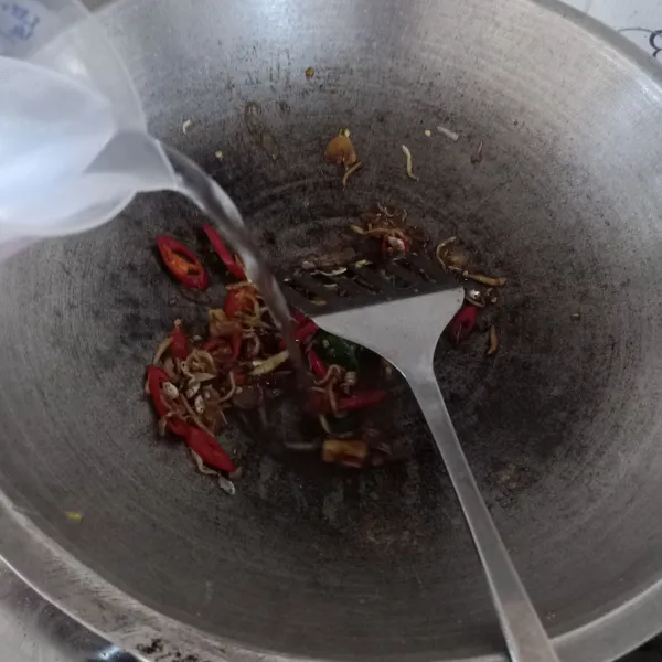 Tambahkan air, kunyit, lada, dan daun jeruk, aduk rata.