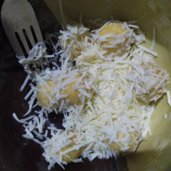 Bulat-bulatkan adonan lalu baluri dengan putih telur hingga semua bagian terlumuri, kemudian gulingkan pada keju yang sudah diparut sebelumnya.