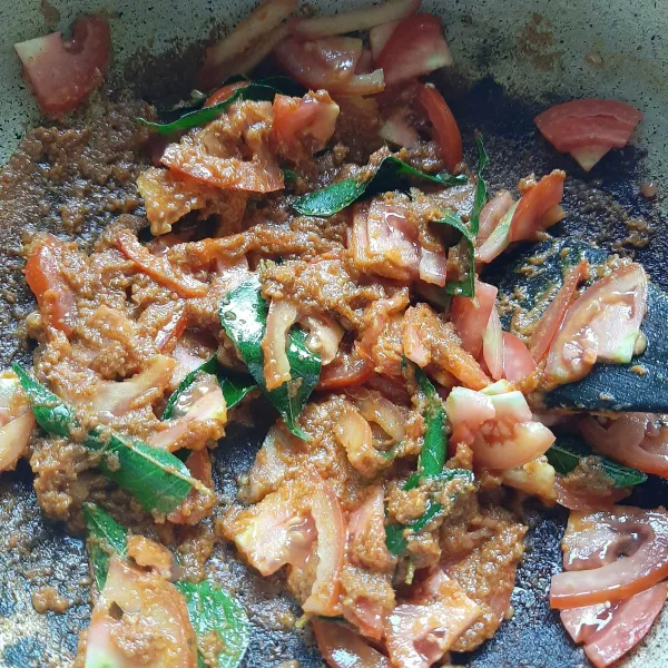Masukkan daun kari dan potongan tomat. Tumis sampai layu.