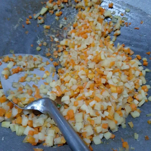 Tumis bawang putih halus sampai harum, masukkan potongan wortel, tambahkan air, masukkan juga kentang. tambahkan bumbu-bumbu. Masak sampai isian matang dan kering. Sisihkan.