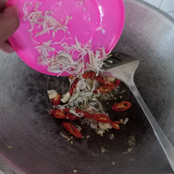 Masukkan teri asin, oseng sampai matang, tambahkan kecap asin dan kecap manis, oseng sebentar.