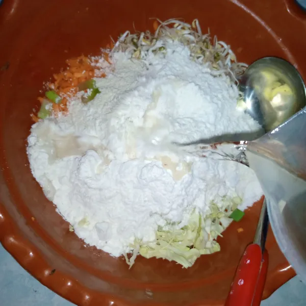 Masukkan tepung kemudian tuang air tambahkan bawang putih bubuk dan kunyit bubuk.