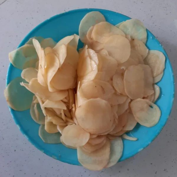 Kupas kentang, cuci bersih, iris tipis lalu rendam sebentar. Lalu tiriskan.