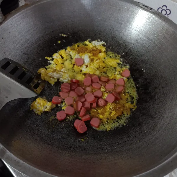 Masukkan sosis, masak sampai setengah matang.