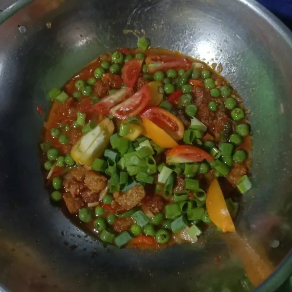 Masukan tomat Dan irisan daun bawang. Biarkan sampai layu. Aduk sebentar lalu angkat dan sajikan