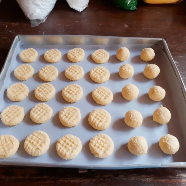 Ambil sedikit adonan, bulatkan. Tata di atas loyang yang sudah dialasi kertas roti. Tekan atasnya dengan garpu.