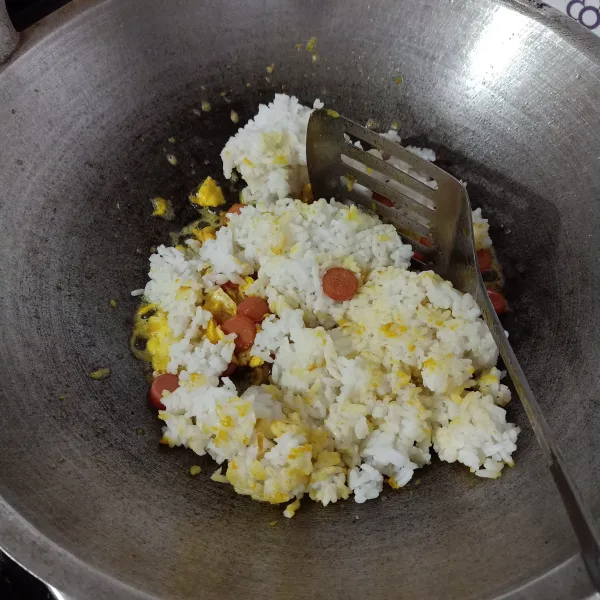 Masukkan nasi, aduk rata sampai warna bumbu tercampur, bumbui gula, lada, garam, dan kaldu bubuk.