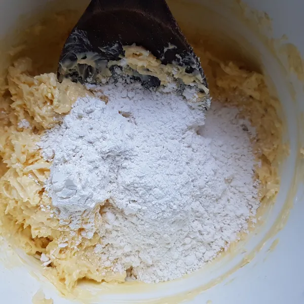Kemudian masukkan tepung terigu secara bertahap dan aduk hingga tercampur rata.