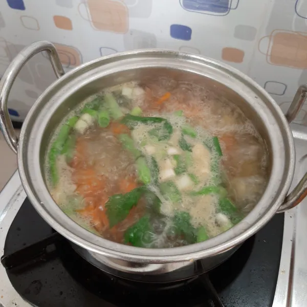Kemudian masukkan kentang, buncis, daun bawang, seledri, garam, kaldu bubuk. Koreksi rasa