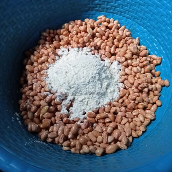 Masukkan 3 sdm campuran tepung, goyang-goyang baskom hingga tepung menempel pada kacang.