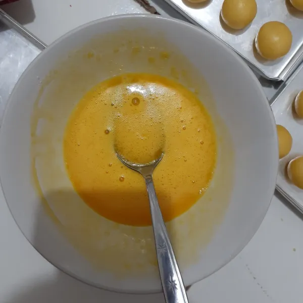 Siapkan mangkuk dengan kuning telur dan susu bubuk untuk olesan nastar.