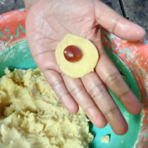Ambil adonan secukupnya dan bentuk pipih, letakkan selai nanas diatasnya.