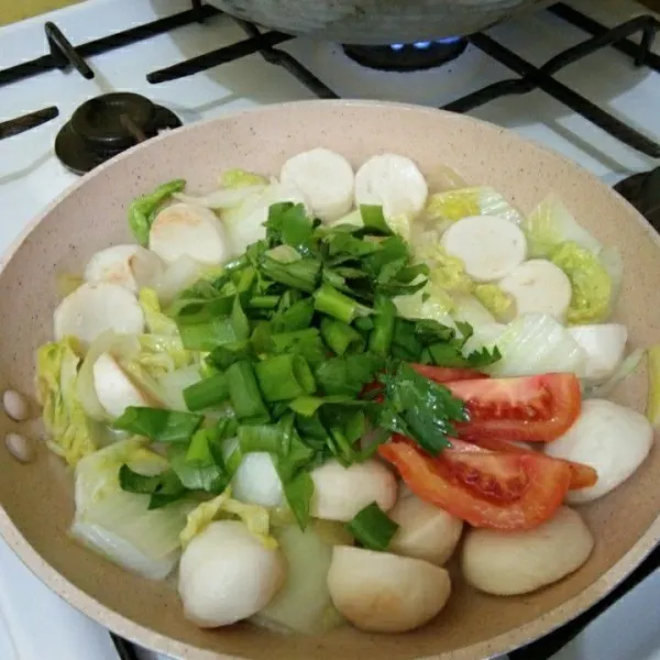 Masukan irisan bawang daun, seledri dan tomat masak hingga matang