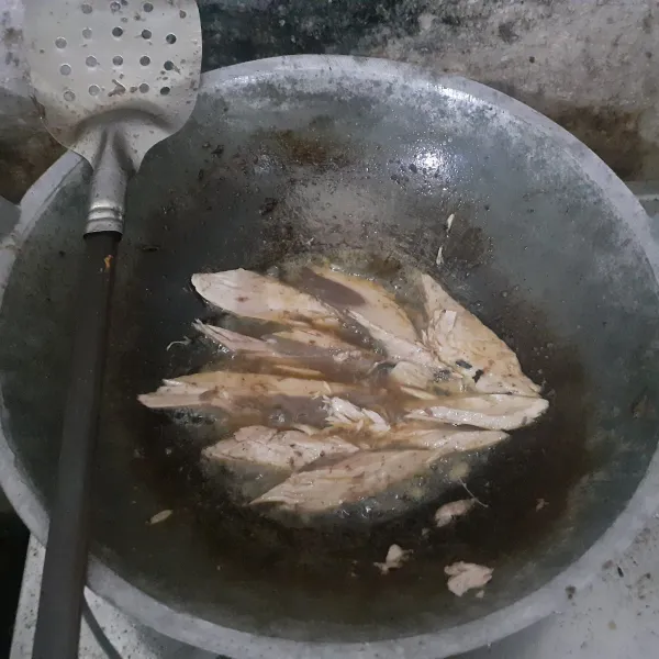 Cuci bersih ikan tongkol, buang durinya, potong sesuai selera, lalu goreng hingga setengah matang.
