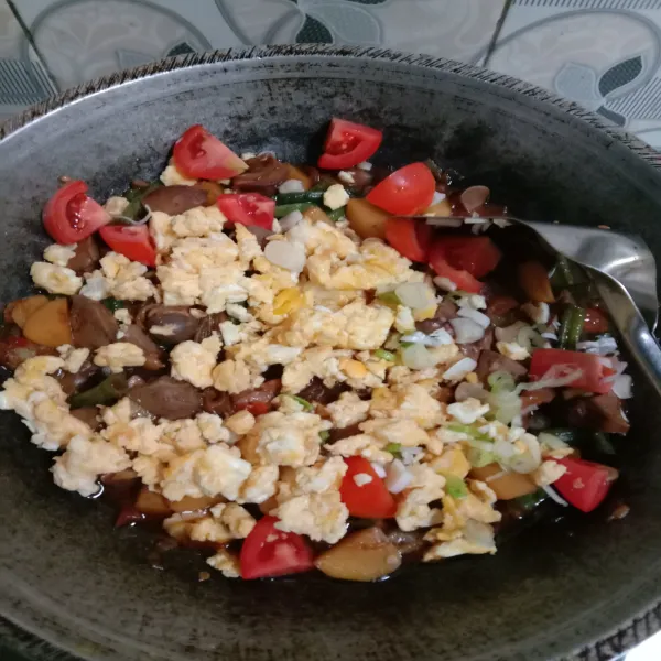 Setelah setengah matang masukkan telur orak arik, daun bawang dan tomat, lalu masak hingga matang.