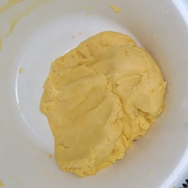 Masukkan tepung terigu secara perlahan, aduk rata hingga tercampur rata dan adonan mudah dibentuk.