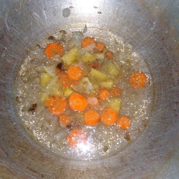 Tumis bawang sampai harum, masukkan air, kayu manis dan cengkeh, aduk rata. Masukkan potongan kentang dan wortel, masak hingga matang.