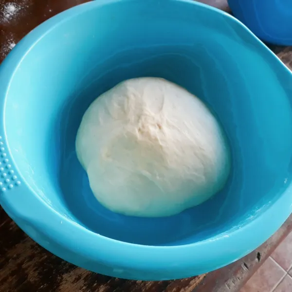 Tambahkan mentega, uleni dengan mixer spiral hingga kalis elastis. Bulatkan adonan, tutup dengan plastik wrap selama 1 jam.