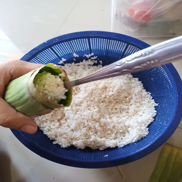 Isi dengan beras 1/2 bagian. sematkan lidi disatu sisinya lagi.