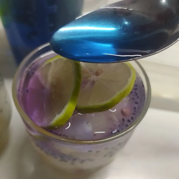 Tuang air teh telang di atas irisan jeruk nipis agar warna berubah jadi ungu. Beri daun mint dan sajikan