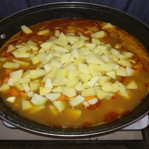 Setelah air mendidih, masukkan potongan kentang, labu siam dan wortel. Aduk merata kemudian biarkan hingga sayuran matang.