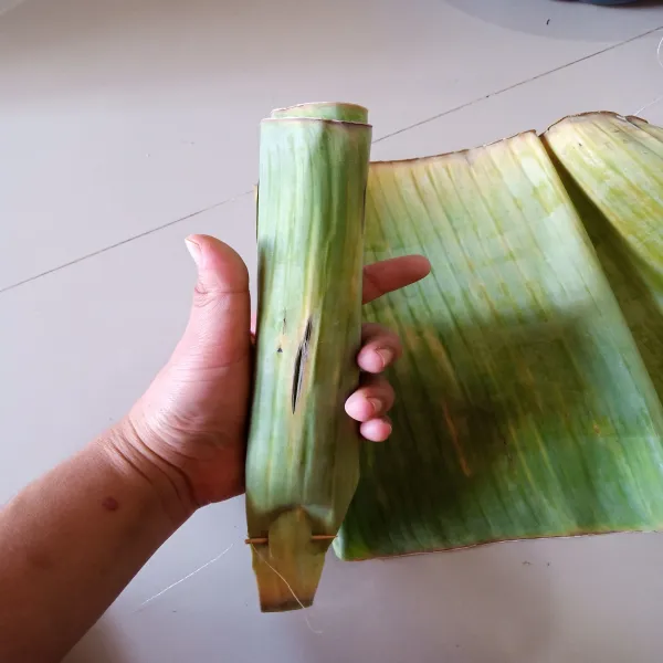 siapkan daun pisang, lap daun sampai bersih. kemudian gulung, sematkan lidi pada Satu ujung.